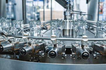 Bottles of vodka upside down transported by conveyor