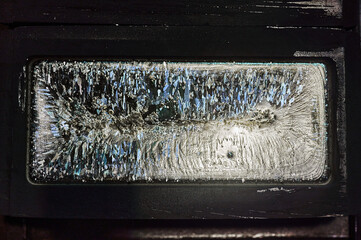 An ingot of silver lies in a graphite mold.