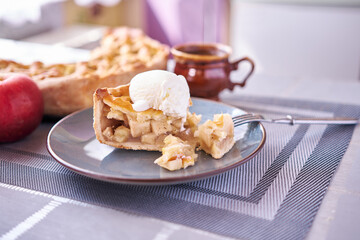 Piece of Fresh homemade Traditional Apple Pie with ice cream on a domestic kitchen