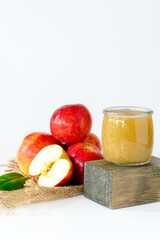 two jars of baby food from apples with pulp, apples on the background are red, vitamin nutrition for children, banner, space for text