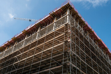 Construction site of a modern building for residential and office space. Blue cloudy sky. Concrete pillars and base.