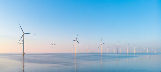 Windmill park in the ocean, drone aerial view of windmill turbines generating green energy...