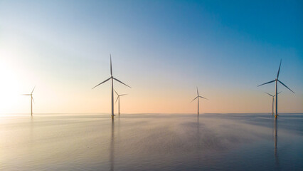 Windmill park in the ocean, drone aerial view of windmill turbines generating green energy...