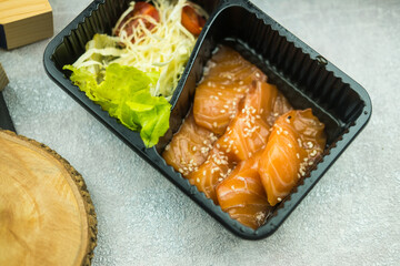 Salmon raw marinated with Korean soy sauce sprinkled with white sesame and sides with fresh vegetable