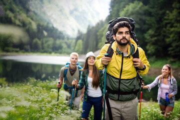 Adventure, travel, tourism, hike and people concept. Group of happy friends with backpack outdoors