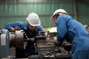 Group of engineer male worker maintaining machine lathe metal at the industry factory. Group of Factory worker check or maintenance CNC machine in industry factory