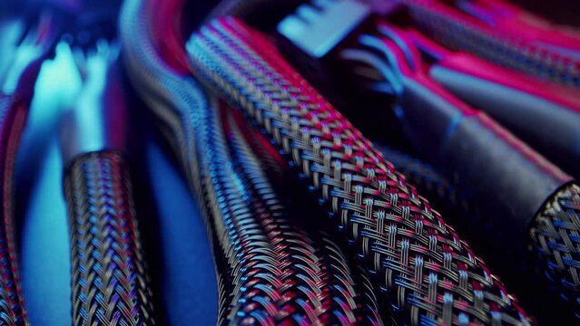Close-up power supply connection cables to computer motherboard wrapped in mesh material. High quality 4k footage