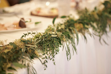 wedding table decoration with green tree branches and flowers. newlyweds wedding table decor
