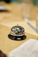 desk bell close-up on a blurred background. desk bell is at the reception. chrome table bell at the...