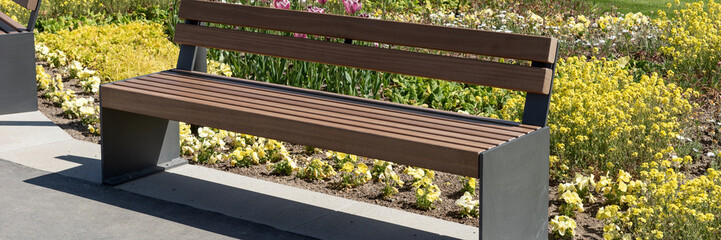 Modern garden bench in the park. Panoramic image