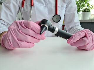 Audiologist ENT with otoscope in clinic closeup