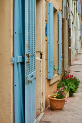 Townhouse with blue door and window shutters in a row in a small village in Provence in France.