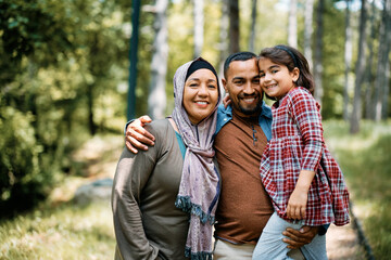 Portrait of happy Middle Eastern family in park looking at camera.