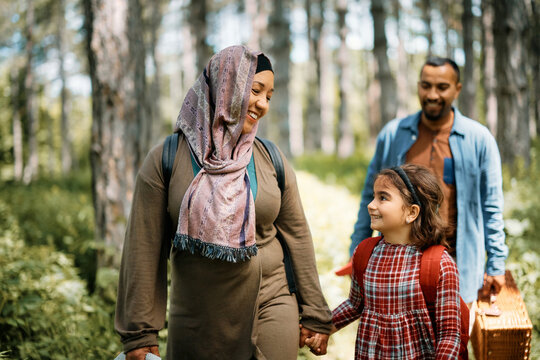 Happy Middle Eastern Mother And Daughter Communicating While Holding Hands During Family Walk In Nature.