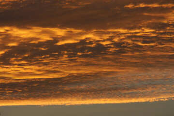 Clouds against the setting sun in summer giving the impression of burning sky.