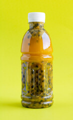 Bottle of passion fruit juice on a green background, macro. Bottle of tropical fruit juice. Healthy food concept.