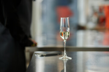a glass of champagne on a metal table in the kitchen. close-up, selective focus