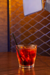 Close-up view of glass with alcohol cocktail on the table in pub. Copy space