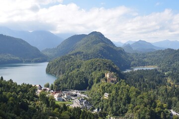 Panoramic view from Neuschwanstein castle at southern Bavaria. Forest, hills and lakes and the Hohenschwangau Castle at the horizon. Bavaria, Germany, September 2021