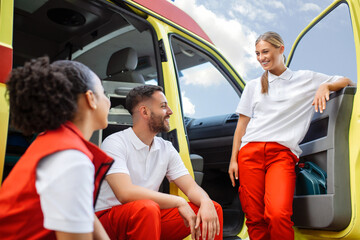 Fototapeta na wymiar Multi-ethnic paramedics standing at the fromt of an ambulance. Emergency doctor and nurse standing in front of ambulance
