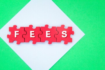 red puzzle with the word fee. the concept of fees