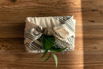  pastel-colored furoshiki gift on wooden background Beautiful gift wrapping and handicraft