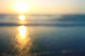 background of blurred beach and sea waves with bokeh lights