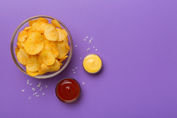 Top view chips with sause in bowl on colored background, top view with copy space
