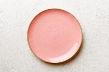 Top view of empty pink plate on cement background. Empty space for your design