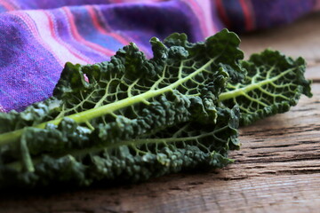 Kale leaves close-up on wooden surface selective focus, organic food, mental food