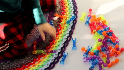 silhouette of a child against the background of a variety of colorful toys in the process of playing selective focus, children's toys