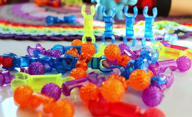 Children's multi-colored toys in the form of unusual figures close-up selective focus on a light surface, logic games for children.