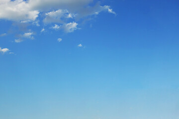 Blue sky background and white clouds soft focus, and copy space horizontal shape.