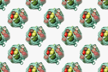 A pattern of vegetables and fruits that are packed in a reusable blue mesh bag on a white background. Fabric shopping bag - zero waste
