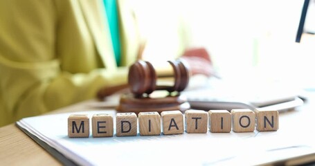 Mediator sitting near gavel of judge and words mediation closeup 4k movie