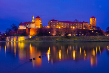 The Wawel Castle of Krakow illuminated at night, reflected on the Vistula River,  Poland