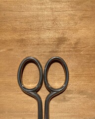 handle of metal scissors on a wooden surface