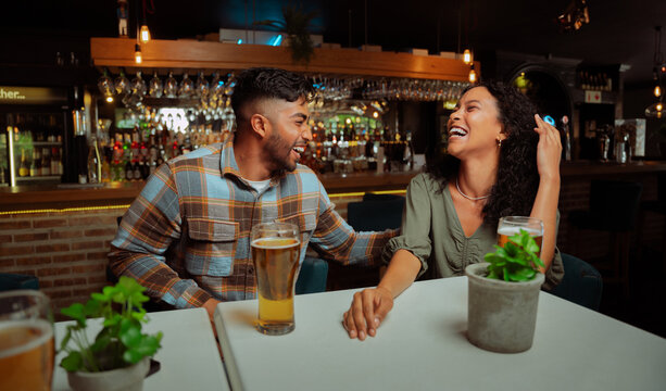 diverse couple of friends out for drinks laughing 