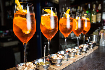 Five glasses of Aperol on the bar. Aperol with orange and ice