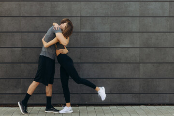 Fit beautiful woman and handsome muscular man after outdoor training, hugging and smiling. Couple. Healthy, sporty lifestyle concept. Real people emotions