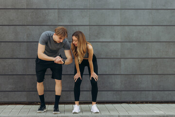 Man showing his marks to a woman on a sports watch after exercise. People using smartwatch