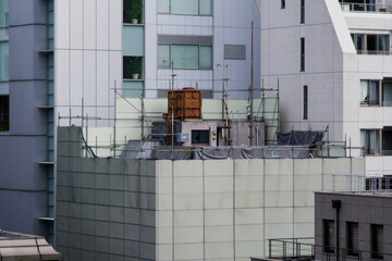 解体工事のために足場とプレートが組まれたビル