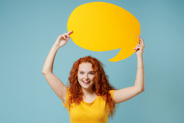 Young redhead woman 20s wear yellow t-shirt hold empty blank Say cloud, speech bubble for...