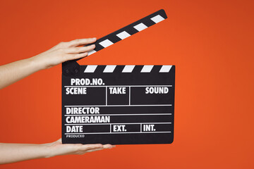 Close up female holding in hand classic director clear empty black film making clapperboard...