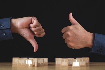 Sign of thumbs up and thumbs down to show the like and unlike feeling. Hands and wood blocks...