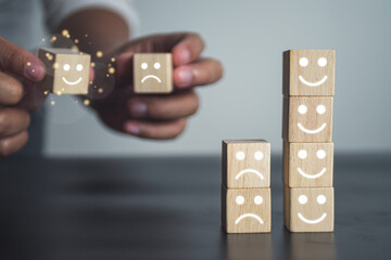 Evaluation and satisfaction concept. Comparison of good and bad job. Close up shot on wood block with emoji face.