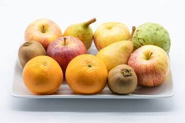 Naklejka na ściany i meble Variety of fresh fruit in a ceramic tray isolated on a white background