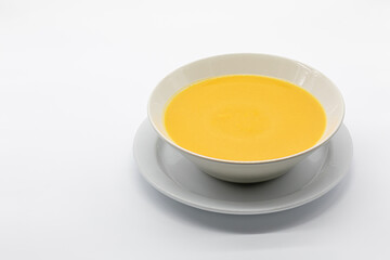 pumpkin and carrot cream with toasted bread in a ceramic bowl isolated on a white background