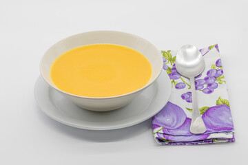 pumpkin and carrot cream with toasted bread in a ceramic bowl isolated on a white background