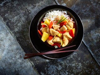 Asiatisches Haehnchengericht Suess Sauer mit Reis auf  dunklem Metallfond